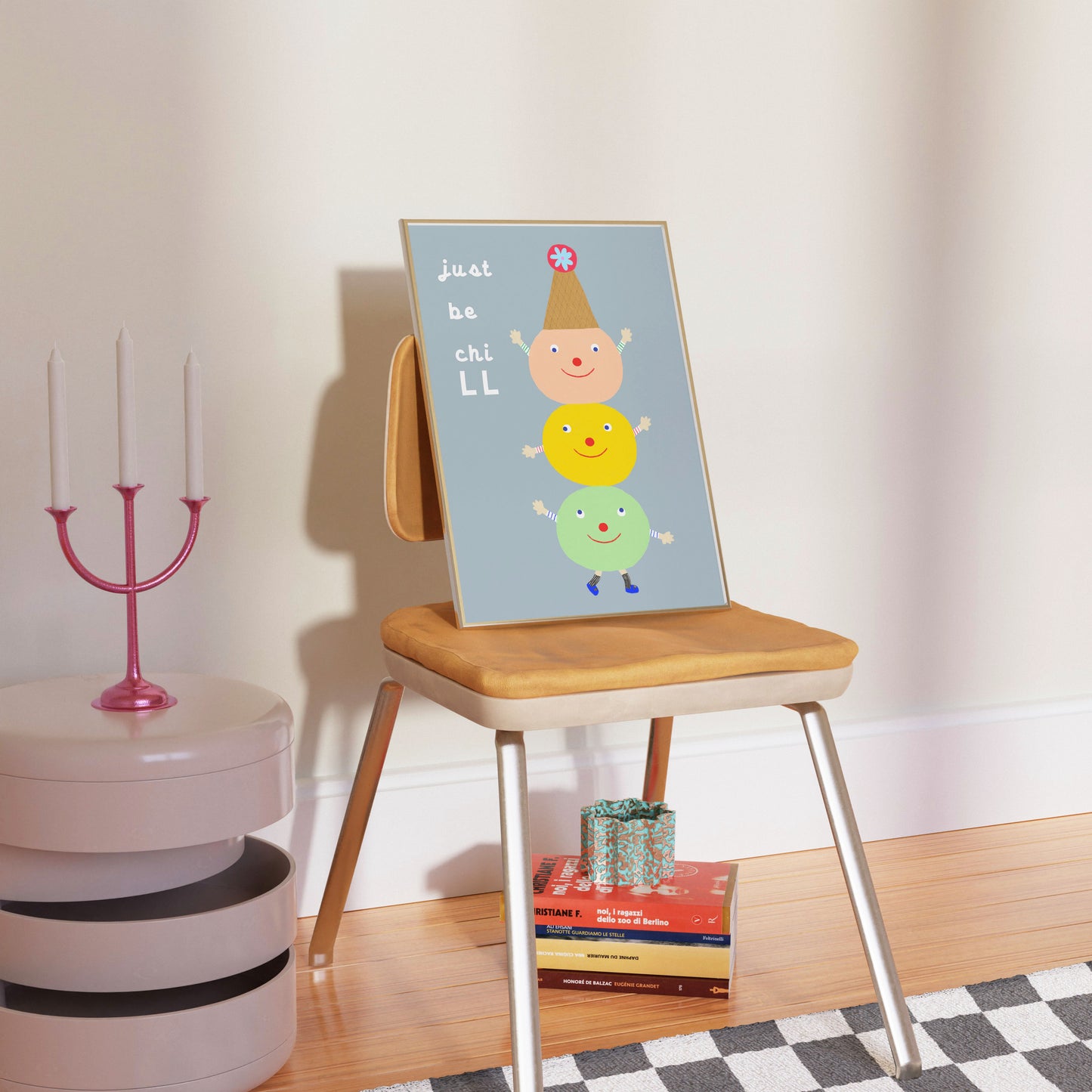 Mock-up of the ‘Just Be Chill’ poster leaning against a wall on a wooden chair in a cozy interior.