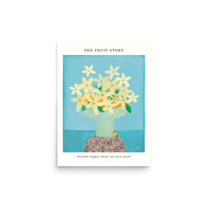 Orange Poster from The Fruit Story showing pale yellow orange blossoms in a light green vase on a patterned table, with the printed message “Wonder begins when we slow down.”